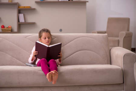 Small girl reading book at homeの写真素材