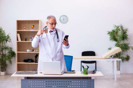 Old male doctor holding pillsの写真素材
