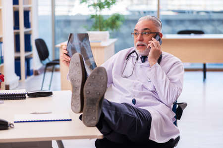 Old male doctor radiologist working in the clinicの写真素材