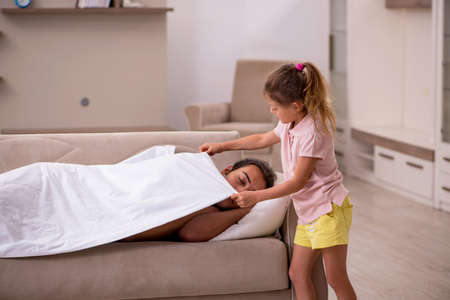 Young man with his daughter at homeの写真素材