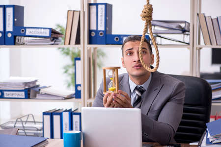 Young male employee committing suicide at workplaceの写真素材