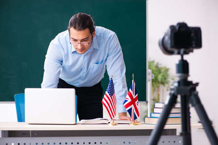 Young handsome teacher recording video for his blogの写真素材