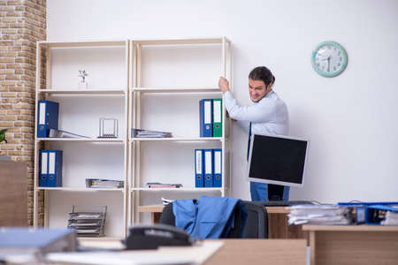 Young male employee unhappy with excessive workの写真素材