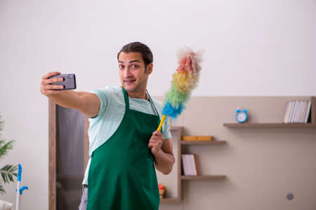 Young male contractor cleaning the houseの写真素材