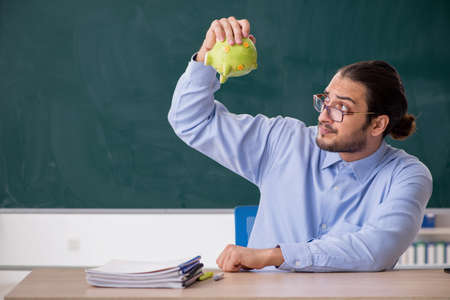 Young underpaid male teacher in the classroomの写真素材