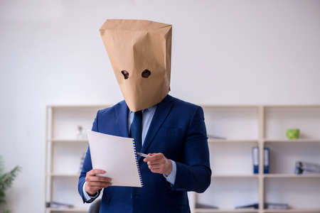 Young male employee with box instead of his headの写真素材