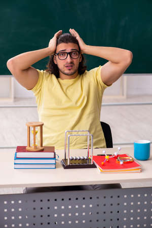Young male student physicist preparing for exams in the classrooの写真素材