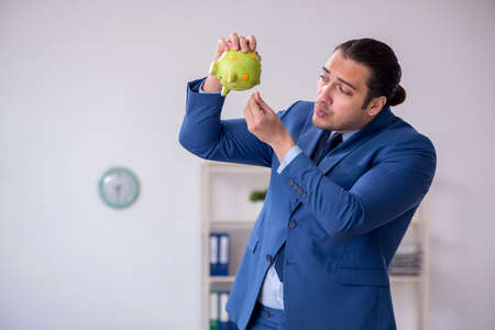 Young male employee in budget planning conceptの写真素材