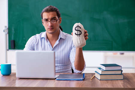 Young male teacher in remuneration conceptの写真素材