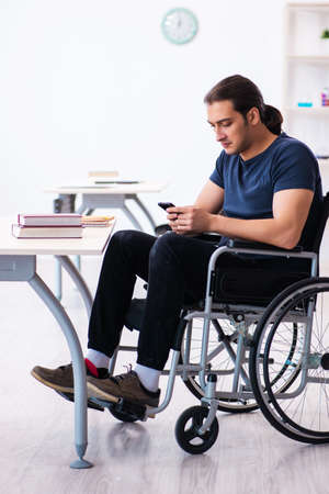 Young male student in wheel-chair preparing for examsの写真素材
