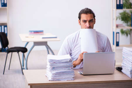 Young male employee unhappy with excessive workの写真素材