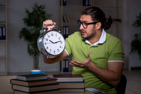 Young student studying at night at homeの写真素材
