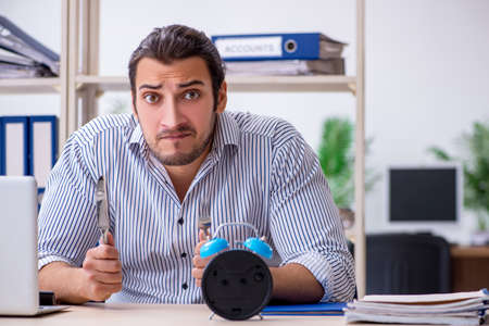 Hungry male employee waiting for food in time management conceptの写真素材