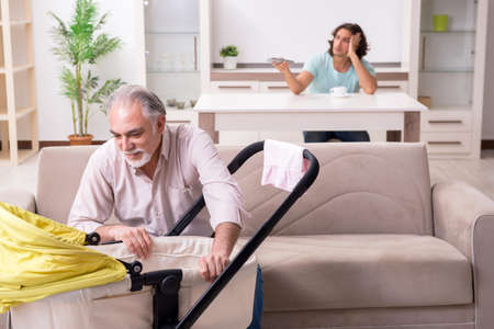 Retired grandfather looking after newborn at homeの写真素材