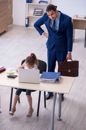 Young male employee and his little girl in the officeの写真素材