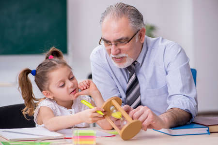 Old teacher and schoolgirl in the schoolの写真素材