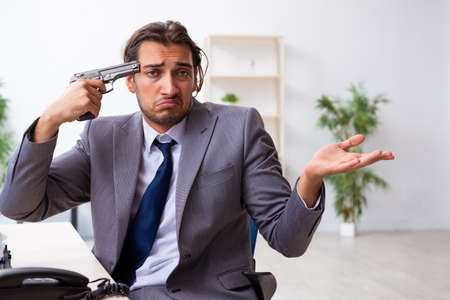 Young male employee unhappy with excessive workの写真素材