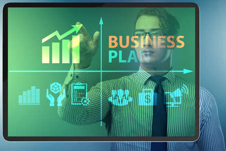 Business plan concept with businessman pressing buttonの写真素材