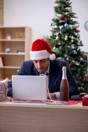 Young male employee celebrating new year in the officeの写真素材