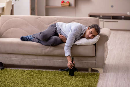 Young drunk man suffering at homeの写真素材