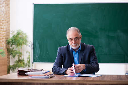 Old male math teacher in the classroomの写真素材