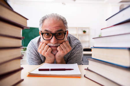 Old male student being exhausted during exam preparationの写真素材