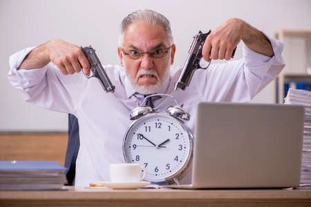 Old male employee in time manegement conceptの写真素材