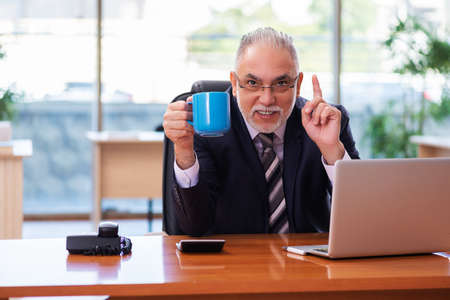 Old businessman employee working in the officeの写真素材