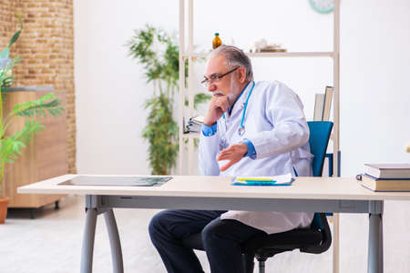 Old male doctor tired after night shiftの写真素材
