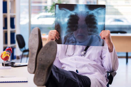 Old male doctor radiologist working in the clinicの写真素材