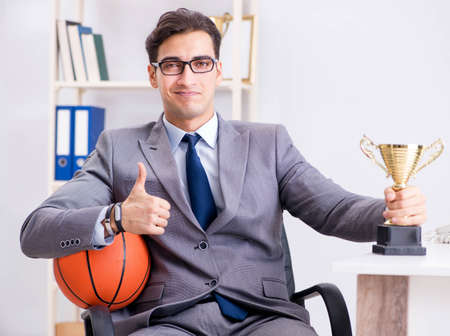 Businessman with prize cup for achievements in officeの写真素材