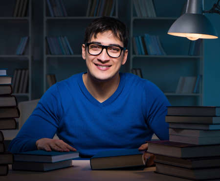 Student preparing for exams late at night in libraryの写真素材