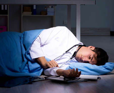 Doctor working night shift in hospital after long hoursの写真素材