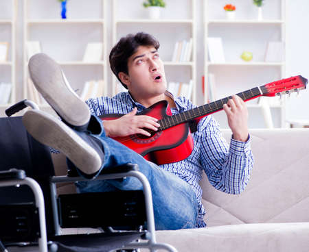 Disabled man playing guitar at homeの写真素材