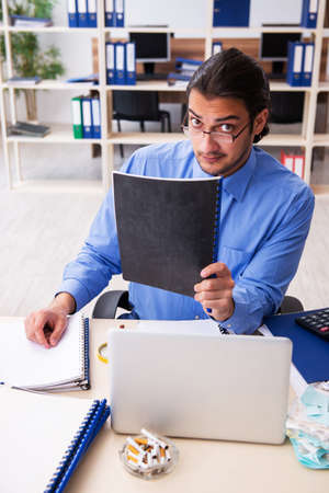 Young male bookkeper in budget planning conceptの写真素材