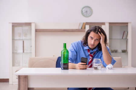 Young male employee being fired from his work at homeの写真素材