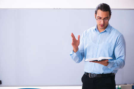 Young handsome teacher in front of whiteboardの写真素材