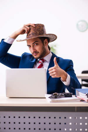 Young businessman cowboy working in the officeの写真素材