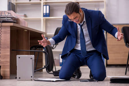 Young male businessman employee unhappy with his workの写真素材