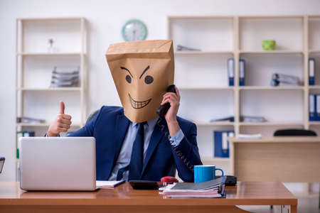 Young male employee with box instead of his headの写真素材