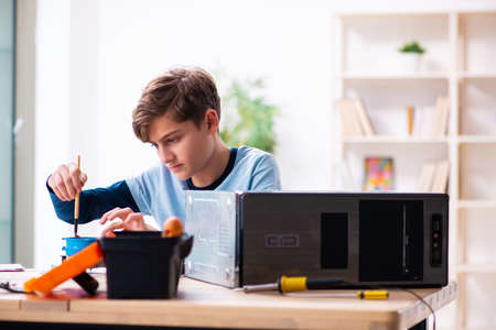 Boy reparing computers at workshopの写真素材
