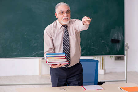 Old male teacher in the classroomの写真素材