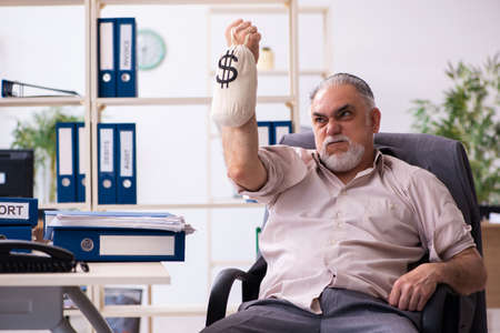 Old male employee with moneybag in retirement conceptの写真素材