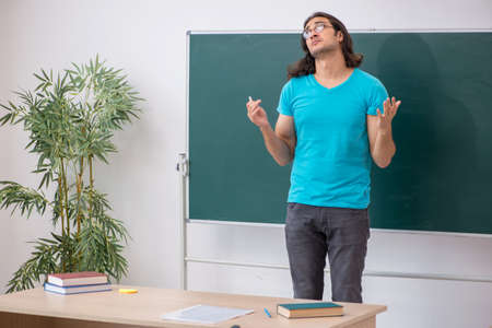 Young male student in front of green boardの写真素材