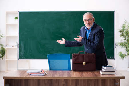 Old male math teacher in the classroomの写真素材