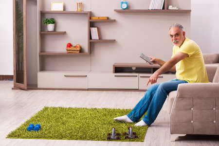 Aged man doing sport exercises at home
