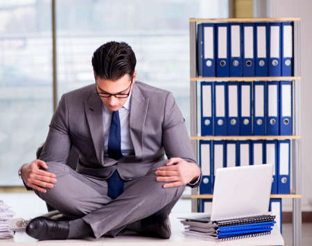 Businessman meditating in the officeの写真素材