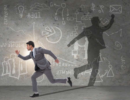 Businessman and his shadow in business conceptの写真素材