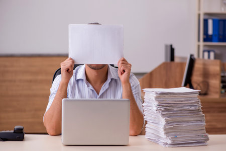 Young male employee holding blank in the officeの写真素材
