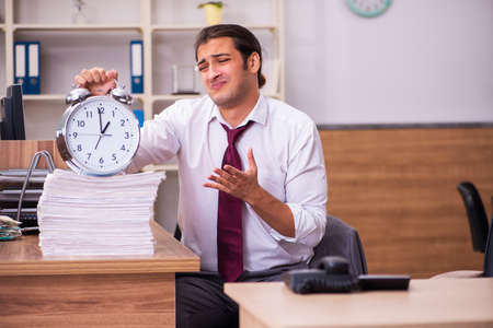 Tired male employee in time management conceptの写真素材